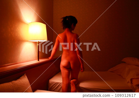 女性裸體背部姿勢,身體輪廓漂浮在暗光中 女性裸體背部姿勢,身體輪廓漂浮在暗光中 109312617