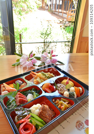 A brightly colored and delicious-looking Shokado bento box placed by the window A brightly colored and delicious-looking Shokado bento box placed by the window 109314205
