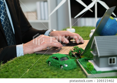 Businessman planning on his laptop with ECO strategy. Quaint Businessman planning on his laptop with ECO strategy. Quaint 109315402