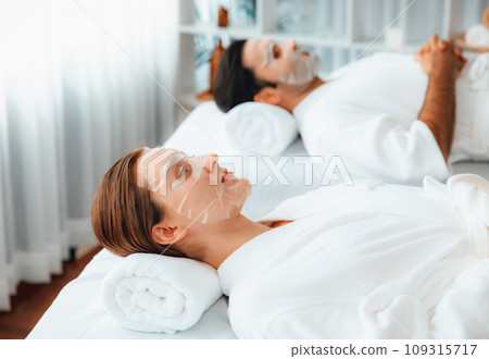 Woman customer indulges in rejuvenating with facial skincare mask. Quiescent Woman customer indulges in rejuvenating with facial skincare mask. Quiescent 109315717