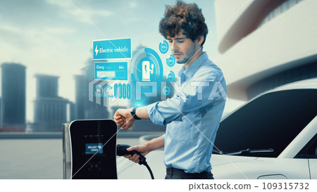 Businessman check EV car battery status on smartwatch hologram. Peruse Businessman check EV car battery status on smartwatch hologram. Peruse 109315732