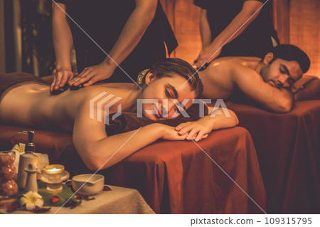 Hot stone massage at spa salon in luxury resort with warm candle light.Quiescent Hot stone massage at spa salon in luxury resort with warm candle light.Quiescent 109315795