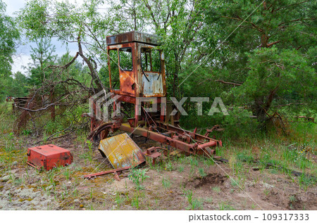 Abandoned agricultural machinery in former mechanized yard of state farm Victory of Socialism in resettled village of Pogonnoye in Chernobyl exclusion zone, Belarus 109317333