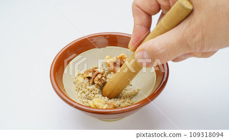 Grind the walnuts in a mortar 109318094