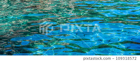 Emerald sea water in sunshine glow as surface background. Summer holidays concept Emerald sea water in sunshine glow as surface background. Summer holidays concept 109318572