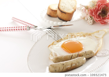 Breakfast of fried eggs, sausage, and French bread 109321473