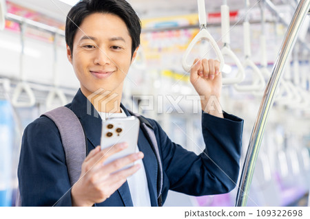 通勤列車上穿著辦公室休閒服的商人。攝影由京王電鐵株式會社提供。 通勤列車上穿著辦公室休閒服的商人。攝影由京王電鐵株式會社提供。 109322698