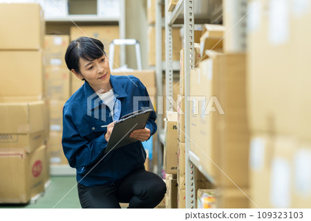 一名中年女工在倉庫檢查物品 109323103