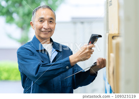 Senior male worker inspecting items in a warehouse 109323119