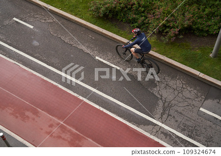 Man riding on bicycle on a bike path in the city. View from above. Man riding on bicycle on a bike path in the city. View from above. 109324674