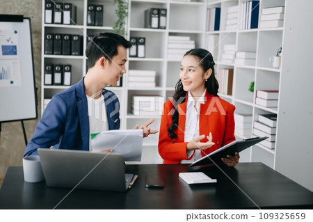 Asian business colleague business presents and explains and using laptop and tablet. Teamwork, financial marketing team, while sitting in home office room. 109325659