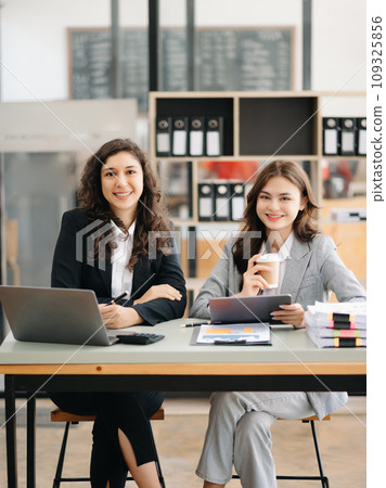 Two businesswoman discuss investment project working and planning strategy with tablet laptop computer in office.. Two businesswoman discuss investment project working and planning strategy with tablet laptop computer in office.. 109325856
