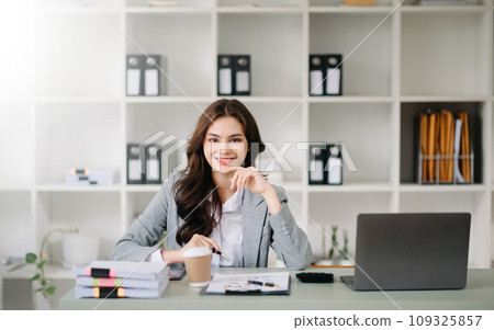 Confident business expert attractive smiling young woman holding digital tablet on desk in office.. Confident business expert attractive smiling young woman holding digital tablet on desk in office.. 109325857