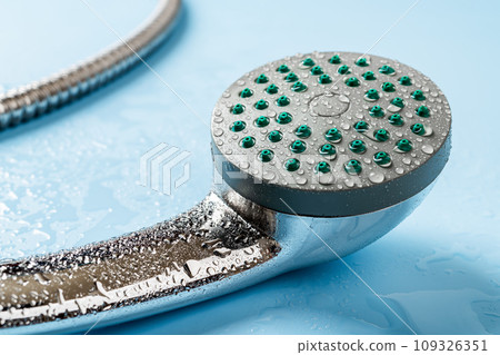 Wet hand held shower head macro. Water drops on a metal handheld shower head. 109326351