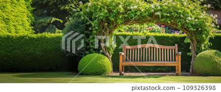 tree arch and wooden garden bench on a grass lawn, beech hedge in backyard 109326398