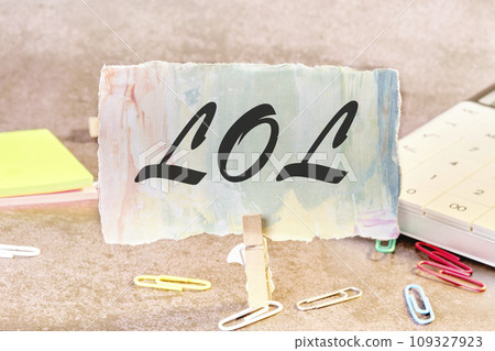 LOL. text on a piece of paper on the table with a clothespin clamped 109327923
