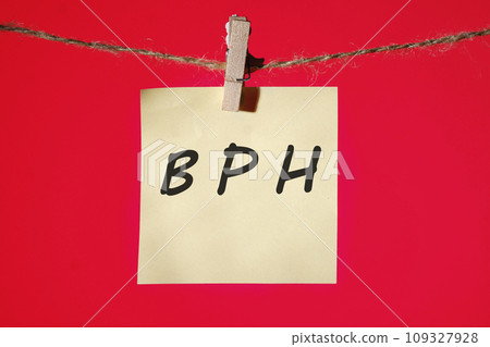 BPH Benign Prostatic Hyperplasia text on a yellow sticker hanging on a rope with clothespins on a red background BPH Benign Prostatic Hyperplasia text on a yellow sticker hanging on a rope with clothespins on a red background 109327928