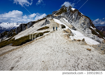 登山者在殘雪中沿著北阿爾卑斯山的津巴嶽山脊線行走 登山者在殘雪中沿著北阿爾卑斯山的津巴嶽山脊線行走 109328615