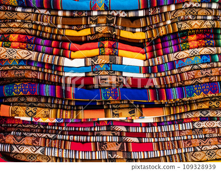 Stack of multicolored andean textile and fabrics in Pisac traditional market, Peru 109328939