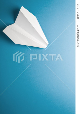 Flat lay of white paper plane on pastel blue color background Flat lay of white paper plane on pastel blue color background 109330586