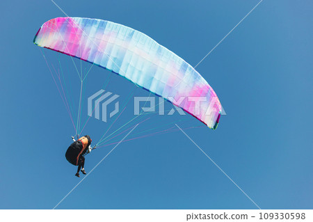 Paraglider in the sky. The sportsman flying on a paraglider. 109330598