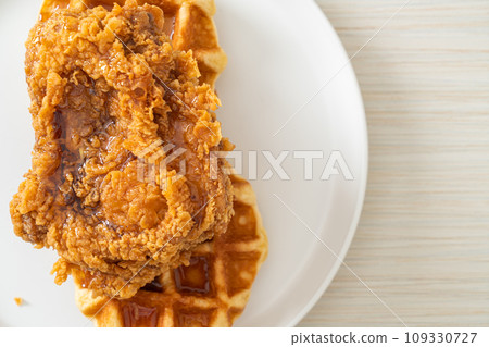 fried chicken waffle with honey or maple syrup 109330727