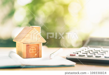 Close up house's model on notebook with calculator, coin and pen on table for Prepare planning of home loan mortgage refinance or retention interest rates, business and financial concept. investment. Close up house's model on notebook with calculator, coin and pen on table for Prepare planning of home loan mortgage refinance or retention interest rates, business and financial concept. investment. 109330814