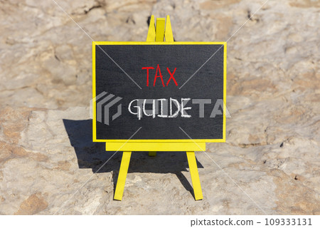 Tax guide symbol. Concept words Tax guide on beautiful black chalk blackboard on a beautiful stone background. Business and Tax guide concept. Copy space. 109333131