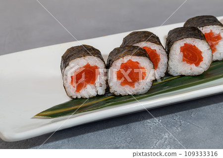 Sushi and rolls with caviar, shrimp and tuna, avocado on a gray background. Sushi and rolls with caviar, shrimp and tuna, avocado on a gray background. 109333316