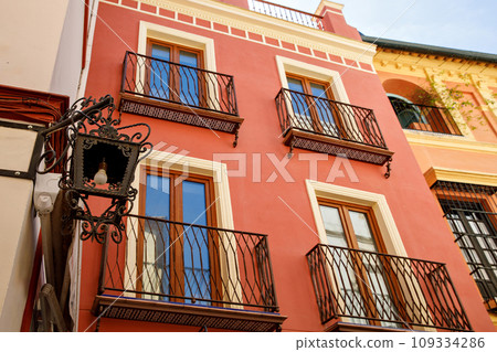Decorative balconies and windows with gates of old city center house in Seville, Spain 109334286