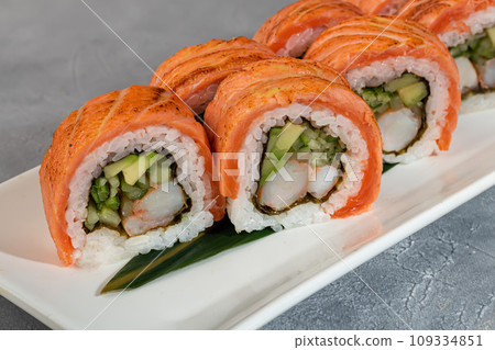 Sushi and rolls with caviar, shrimp and tuna, avocado on a gray background. Sushi and rolls with caviar, shrimp and tuna, avocado on a gray background. 109334851