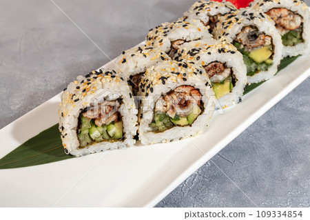 Sushi and rolls with caviar, shrimp and tuna, avocado on a gray background. Sushi and rolls with caviar, shrimp and tuna, avocado on a gray background. 109334854