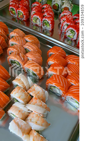 Sushi and rolls with caviar, shrimp and tuna, avocado on a gray background. Sushi and rolls with caviar, shrimp and tuna, avocado on a gray background. 109334859