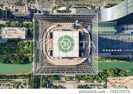 Helipad on the rooftop of the modern skyscraper. Glass business offices district. Aerial drone view of helipad on the roof of a skyscraper in downtown. Helipad on the rooftop of the modern skyscraper. Glass business offices district. Aerial drone view of helipad on the roof of a skyscraper in downtown. 109335078