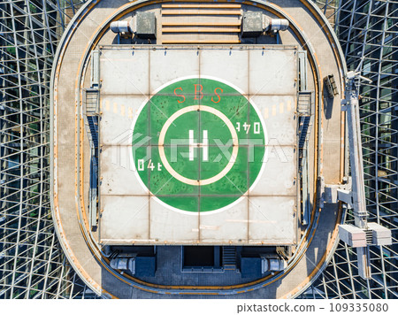 Helipad on the rooftop of the modern skyscraper. Glass business offices district. Aerial drone view of helipad on the roof of a skyscraper in downtown. Helipad on the rooftop of the modern skyscraper. Glass business offices district. Aerial drone view of helipad on the roof of a skyscraper in downtown. 109335080