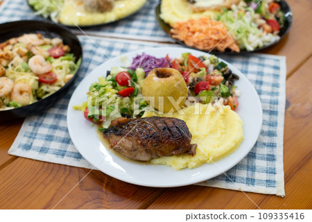 Home made meat dish with salads, in hands dinner time duck and apple Home made meat dish with salads, in hands dinner time duck and apple 109335416