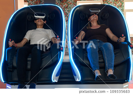 Virtual reality attraction, son and mother experience adrenaline from virtual reality. Virtual reality attraction, son and mother experience adrenaline from virtual reality. 109335683