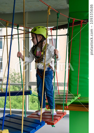 Children's cableway in the playroom, little girl passes the cableway. 109335686