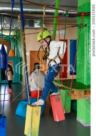 Happy girl passes the cableway, active recreation in the game room. 109335688