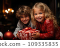 Happy little kids with a festive red and white Christmas gift 109335835