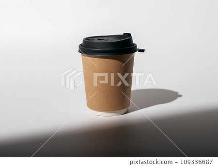 Kraft paper cup mockup, coffee mug to go covered with black lid Kraft paper cup mockup, coffee mug to go covered with black lid 109336687