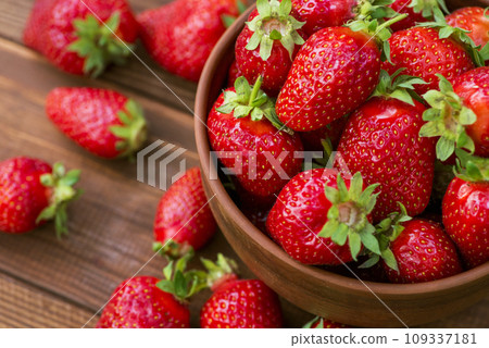 Fresh strawberries in a bowl on wooden table. Strawberry in a Bowl. Top view Fresh strawberries in a bowl on wooden table. Strawberry in a Bowl. Top view 109337181