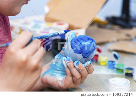Kid is dyeing Easter eggs 109337214