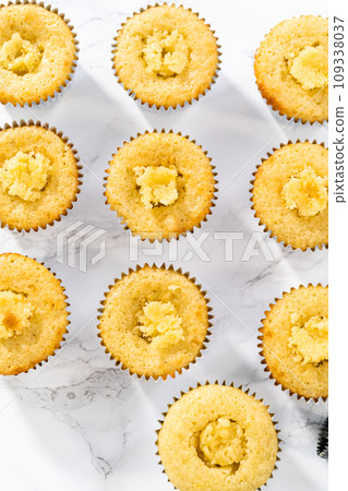 Filling lemon cupcakes with lemon filling. 109338037