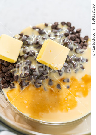 Melting white chocolate chips and other ingredients in the double boiler to prepare chocolate pistachio fudge. 109338150