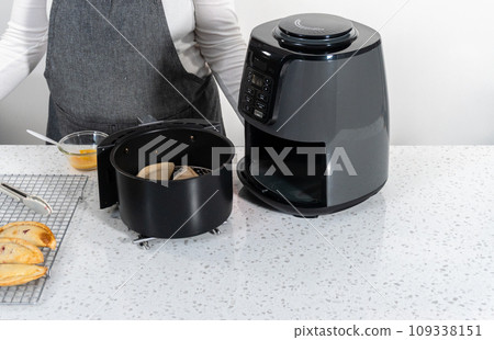 Frying sweet cherry empanadas in the air fryer. 109338151