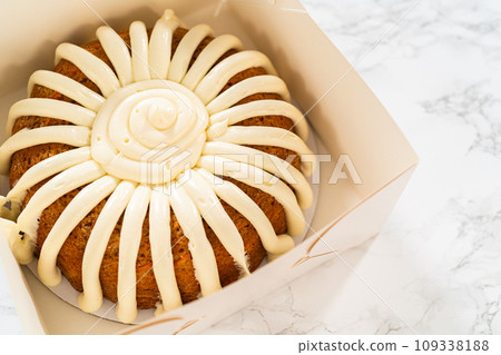 The Carrot Bundt Cake is carefully packaged into a white paper bundt cake box, ready for gifting or sharing. 109338188