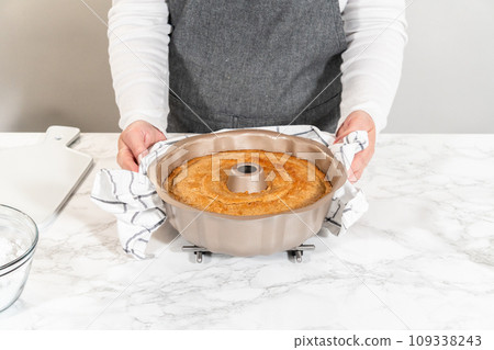 The freshly baked Carrot Bundt Cake is left to cool on the kitchen counter, filling the air with delightful aromas. 109338243