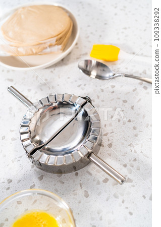 Filling empanada dough with cherry pie filling to make sweet cherry empanadas in the air fryer. 109338292