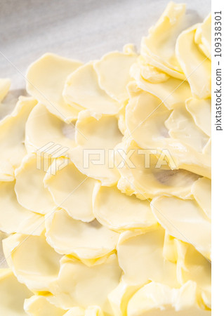 Spreading unsalted butter at room temperature to prepare a vegetarian party butter board for a party. Spreading unsalted butter at room temperature to prepare a vegetarian party butter board for a party. 109338301
